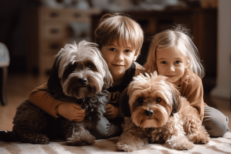 Enthusiastic children with two cuddly dogs in cozy indoor setting.