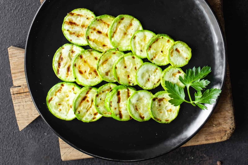 Healthy grilled zucchini slices served on a black plate for nutritious meals.