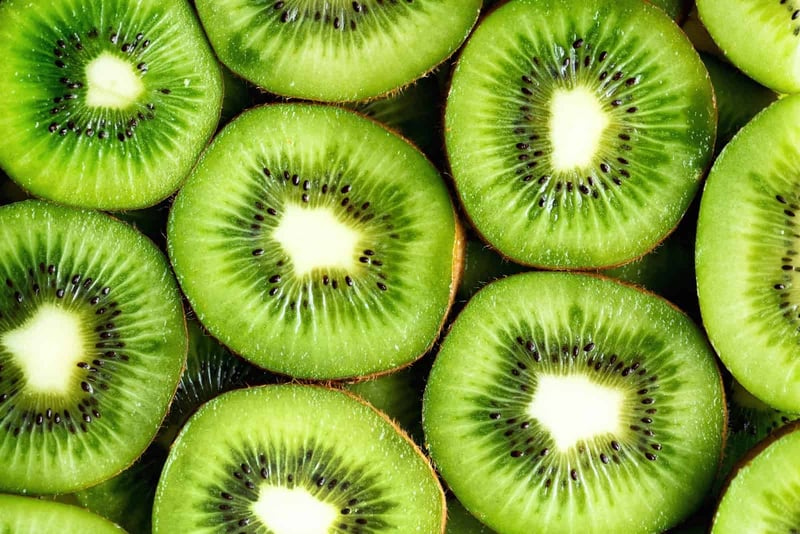Vibrant kiwi slices showcasing bright green flesh and tiny black seeds, symbolizing freshness and health.