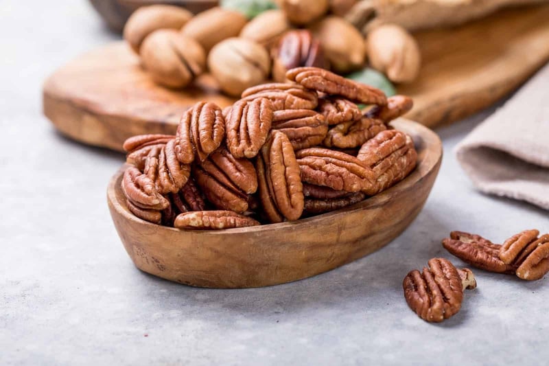 Healthy dog-friendly nuts like pecans and walnuts in wooden bowls.