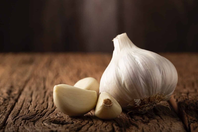 High-quality garlic image showing fresh whole bulb and peeled cloves, ideal for culinary use.