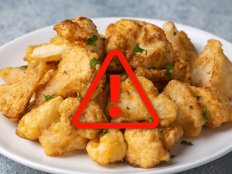 Delicious crispy fried chicken with herbs on a white plate, highlighting food safety warning.