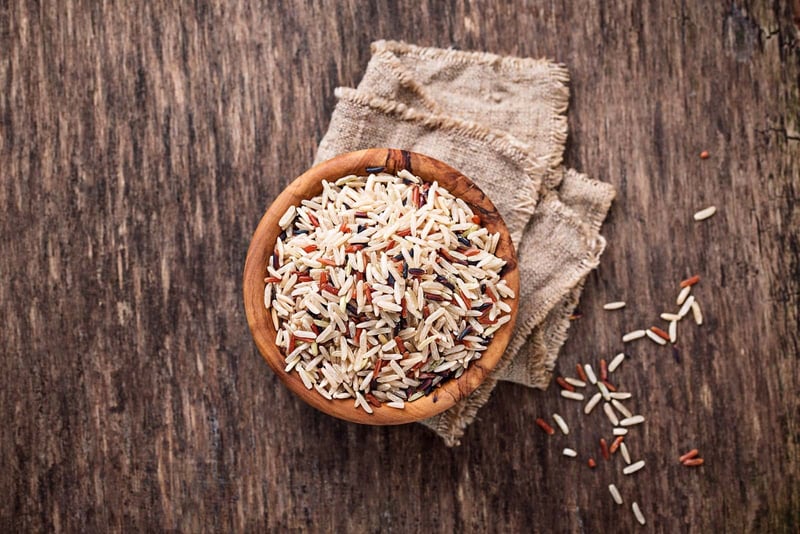 Healthy pet rice food in wooden bowl on rustic table, natural dog nutrition.