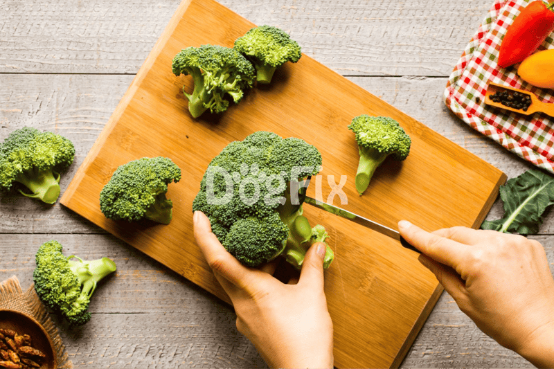 Bright green broccoli florets on wooden cutting board for nutritious dog food recipes.