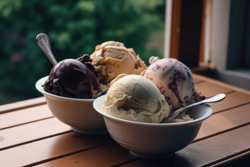 Delicious assorted ice cream scoops in bowls on a wooden table with a scenic outdoor view.