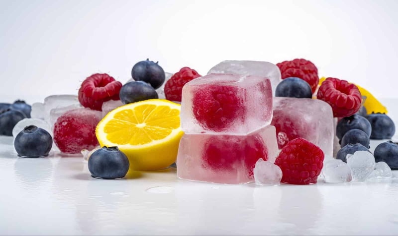 Fresh frozen berry and lemon treats, perfect for summer, featuring raspberries, blueberries, and citrus slices for a healthy snack.