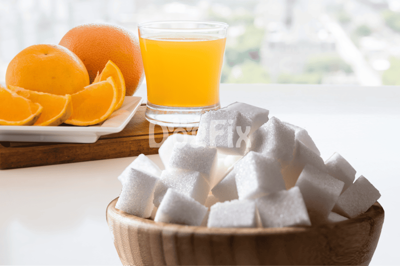Fresh orange juice, oranges, and sugar cubes on a bright table for dog-friendly snacks.