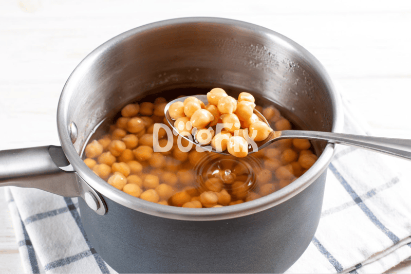 Image shows chickpeas in a saucepan, preparing nutritious dog food meal.