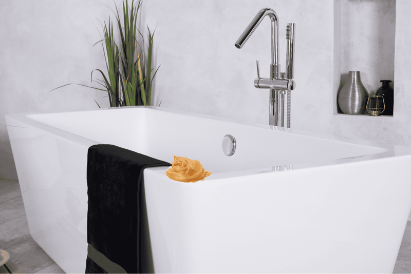 Modern bathroom tub with sleek chrome fixture, black towel, and decorative vases.