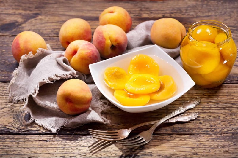 Fresh peaches and peach preserves in a bowl, ideal for healthy snacks and desserts.
