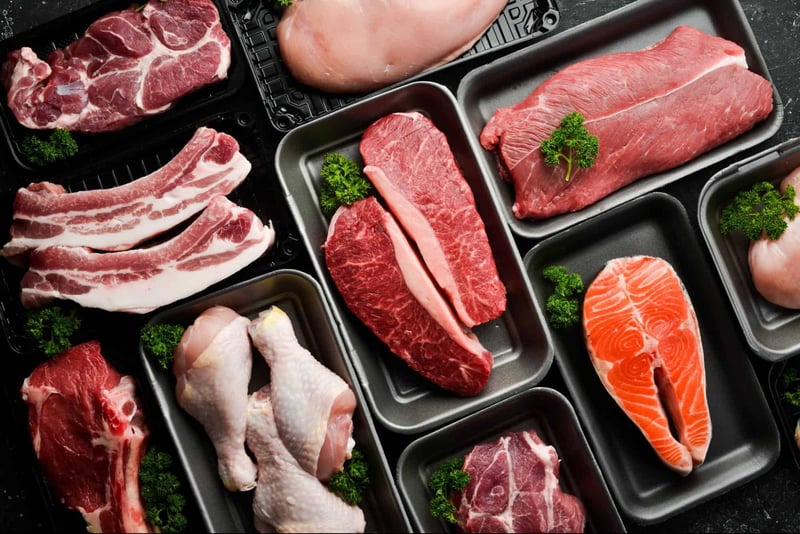 Assorted fresh meats displayed on black trays, suitable for dog nutrition and pet health.