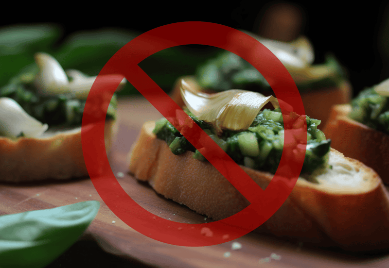 Close-up of a bruschetta with garlic, spinach, and cheese, crossed out for mold warning.