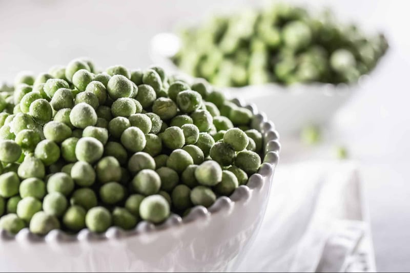 Close-up of frozen green peas in a white bowl, healthy vegetable snack, farm-fresh, vegetarian food, natural produce, organic peas.