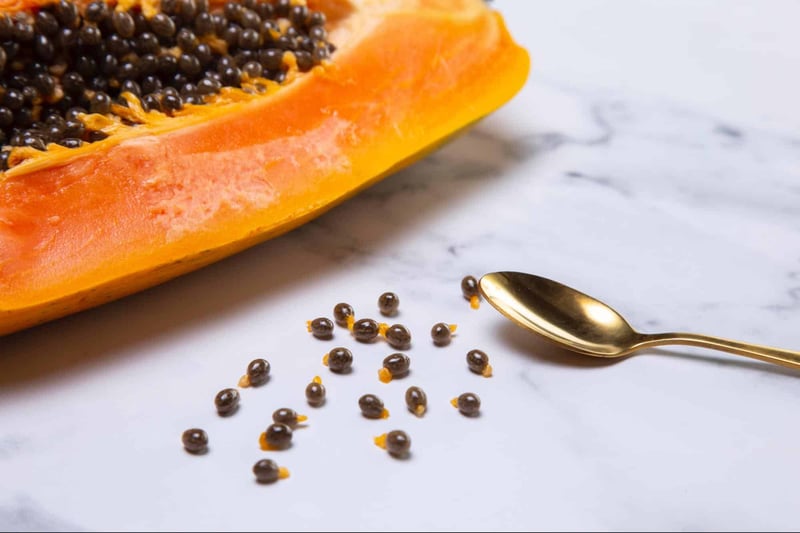 Papaya fruit sliced with black seeds on white marble surface, organic superfood for pets.