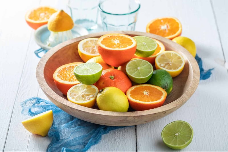Fresh citrus fruits including lemons, limes, oranges, and a grapefruit, for dog-friendly snacks or treats.