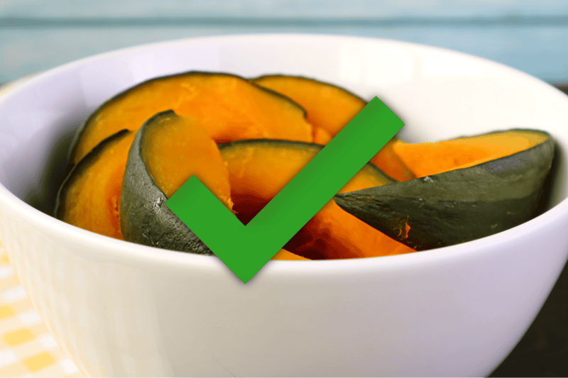 Fresh pumpkin slices in a white bowl, a healthy, nutritious dog treat, high in fiber and beneficial for digestion.