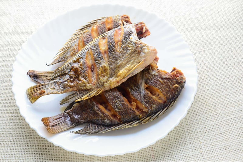 Fresh grilled whole fish served on a white plate, perfect for seafood lovers and healthy meals.