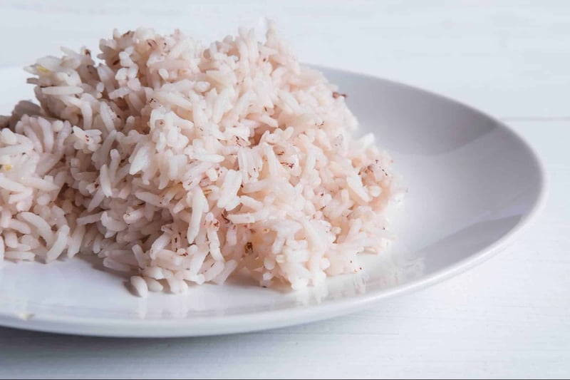 Healthy cooked rice for dogs on a white plate, ideal for dog nutrition and digestion.