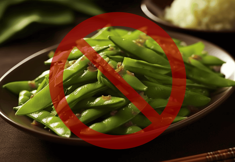 Alt text: Fresh green beans on a plate with a red prohibition symbol, indicating they are not suitable for dogs.