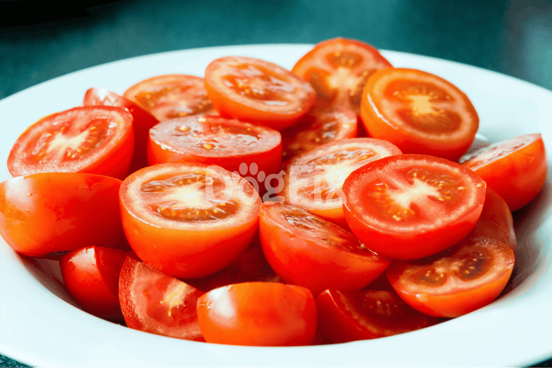 Vibrant sliced cherry tomatoes in a white bowl, ideal for healthy dog treats and canine nutrition.