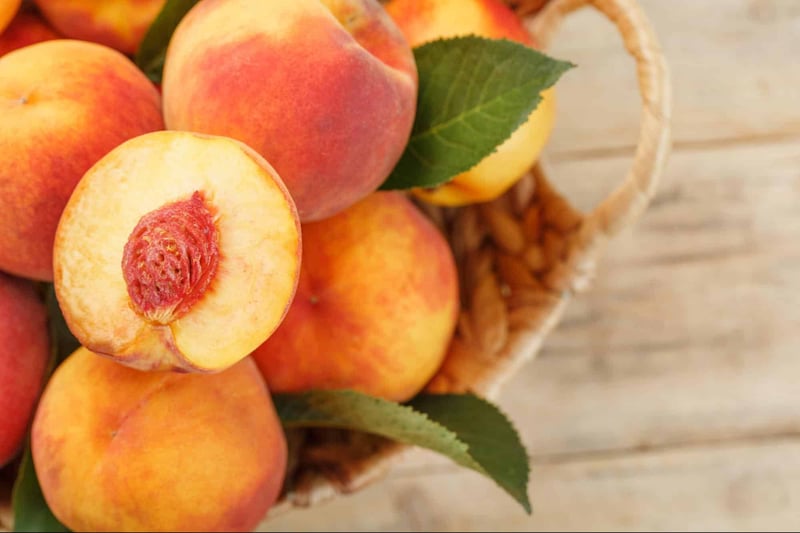 Fresh peaches in basket with leaves, healthy and delicious fruit.