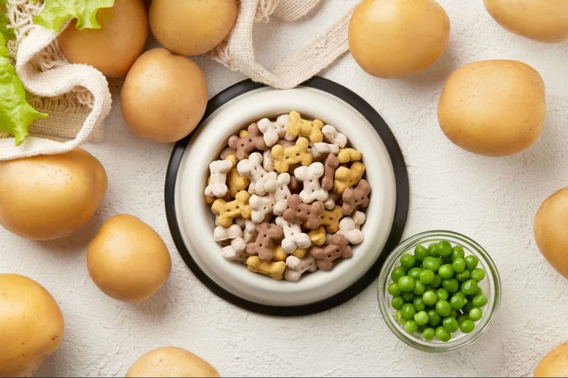 Nutritious dog food bowl with bone-shaped kibble, surrounded by fresh potatoes and green peas.