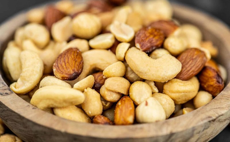 Pet-safe mixed nuts with almonds, cashews, and hazelnuts in a wooden bowl.