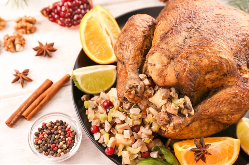Juicy roasted turkey served with orange, lemon, and traditional stuffing on festive table.
