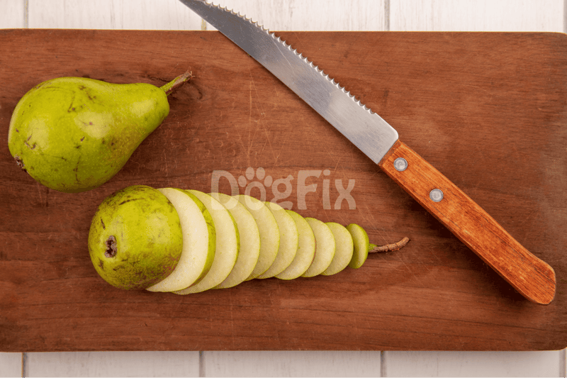 Pear sliced on wooden cutting board with a sharp knife, fresh fruit for healthy snacks or recipes.
