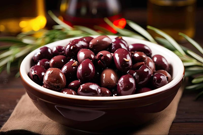 Black olives in a bowl for healthy snacking or cooking, rich in flavor and nutrients.