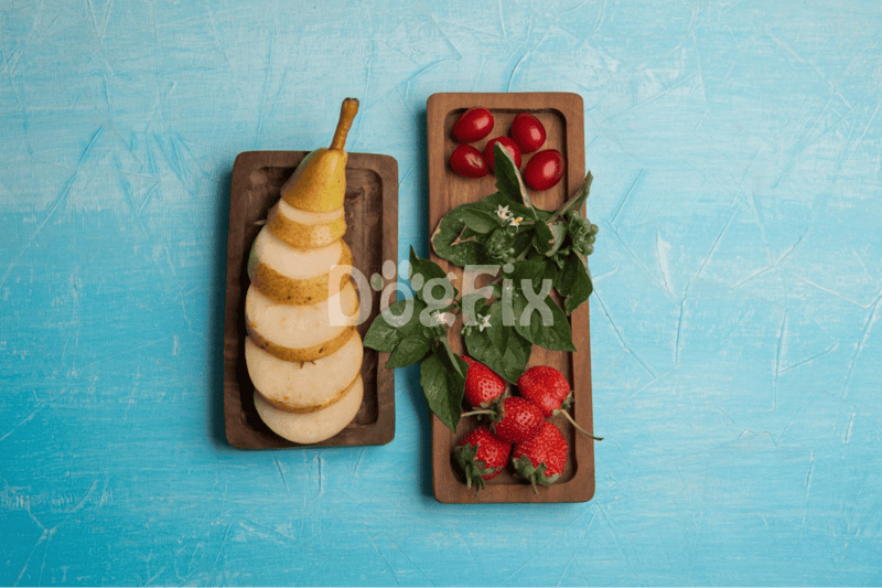 Healthy dog snacks with fresh strawberries, cherry tomatoes, leafy greens, and pear slices.