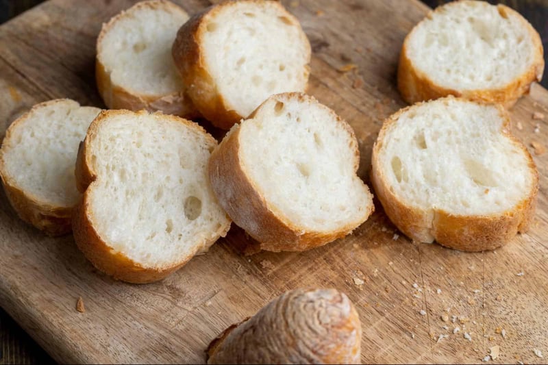 Delicious homemade bread slices on wooden cutting board, perfect for sandwiches or toast.