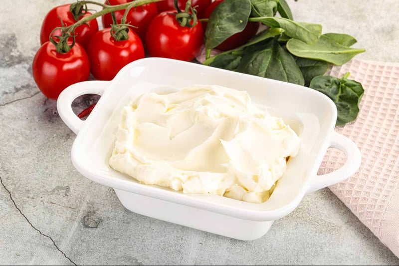 Close-up of creamy cheese spread with smooth texture and swirled appearance.