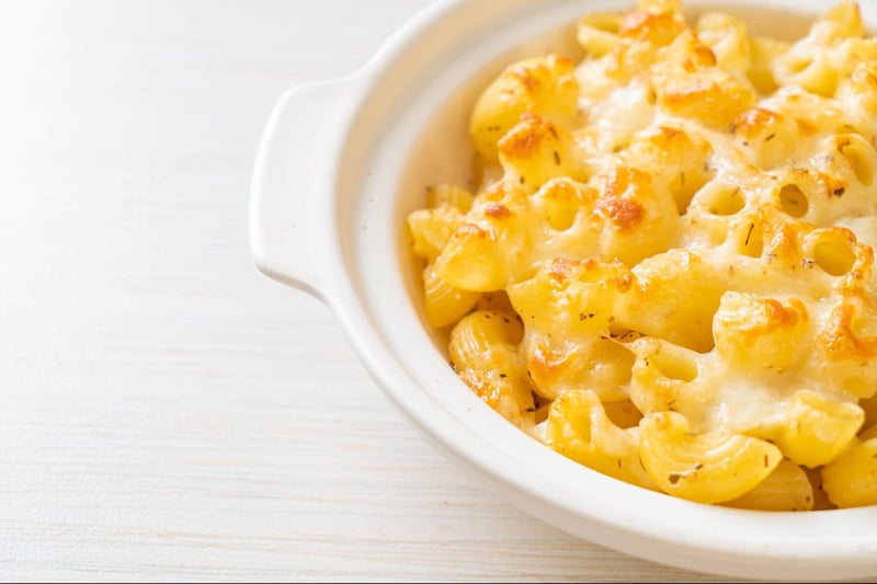 Dog-friendly cheesy macaroni and cheese in a white bowl, perfect for canine dietary treats.