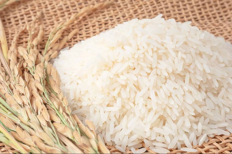 Pure white rice grains on natural woven mat with wheat stalks for nutritious dog diet.