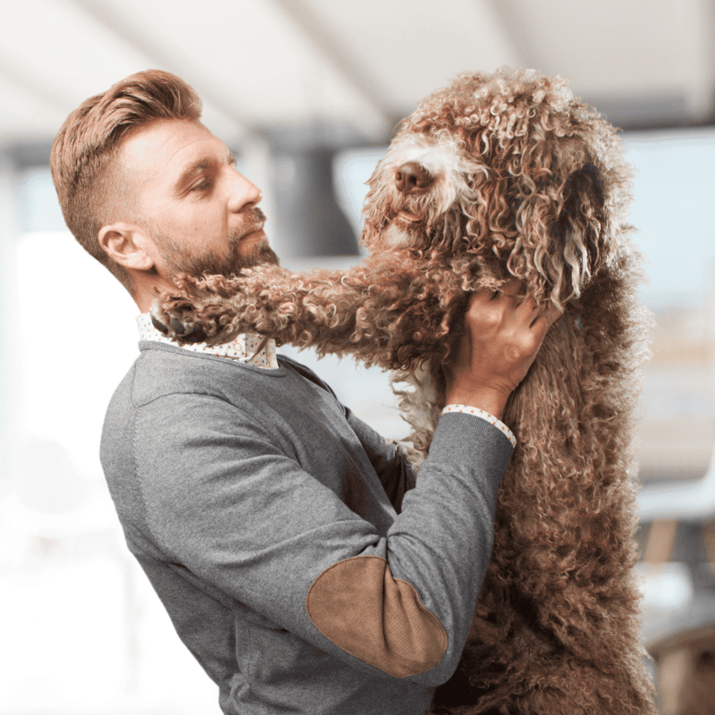 A happy dog and owner share a joyful moment, emphasizing pet love and care.