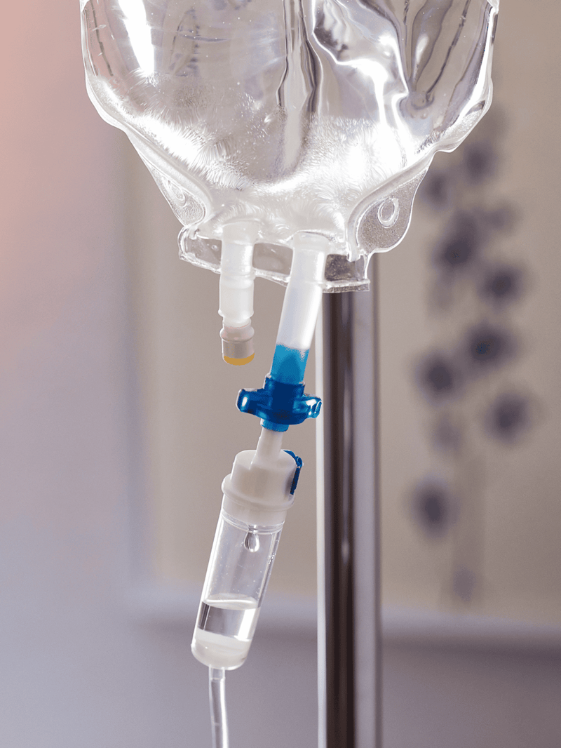 Close-up of a clear IV drip bag used for administering fluids to pets.