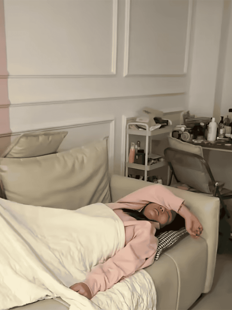 Young girl peacefully sleeping on a beige sofa in cozy home setting.