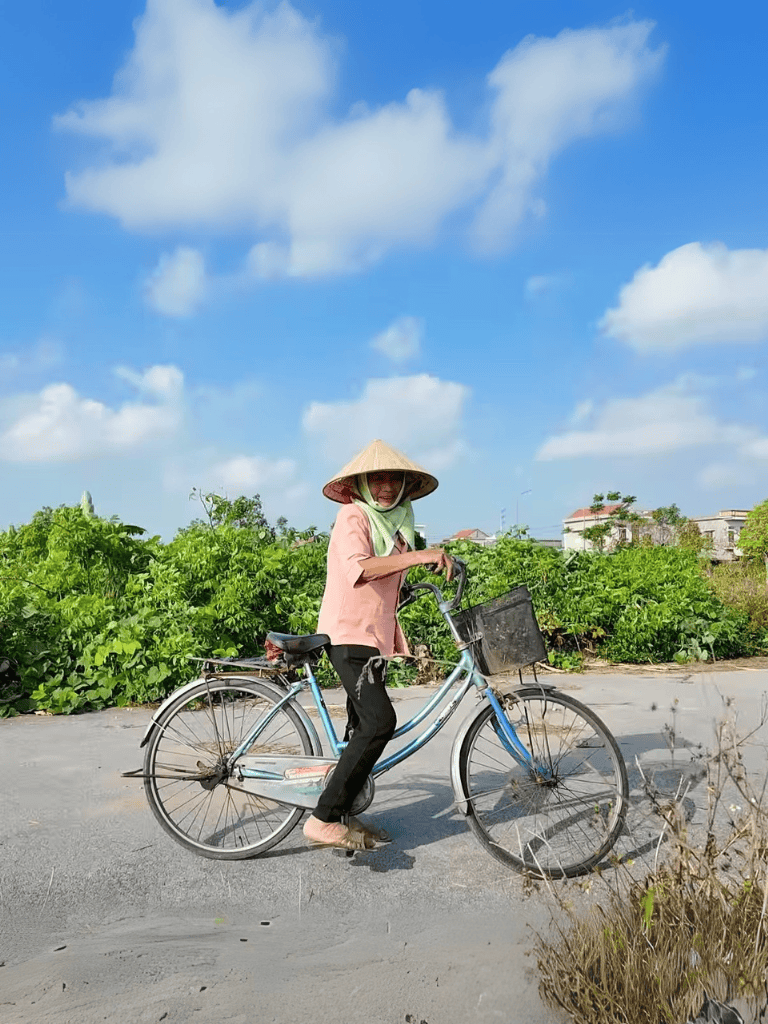 Traditional Vietnamese conical hat protects rider from sun.