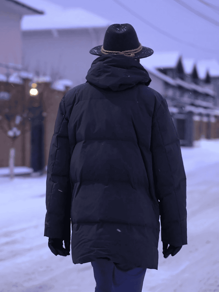 Warm winter coat for men in snowy outdoor setting.