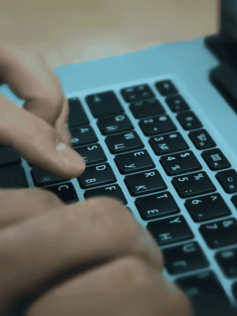 Close-up of a person's hands typing on a modern computer keyboard for work or gaming.