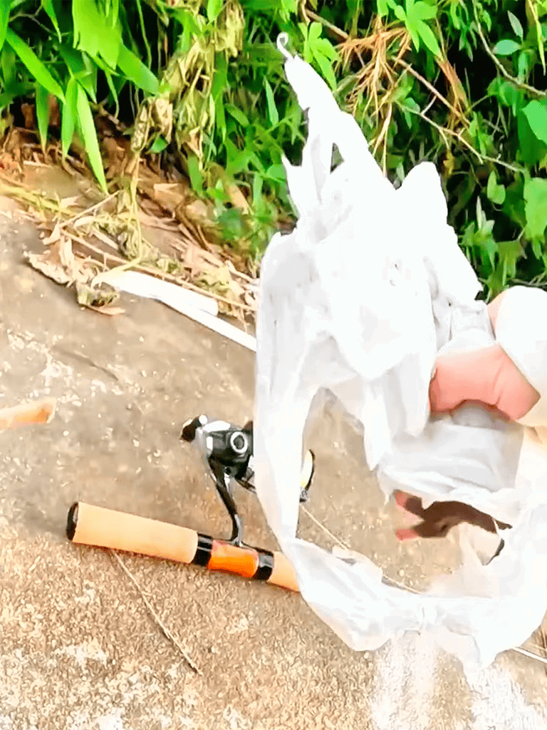 Dog waste bag and scooper for waste disposal on outdoor concrete surface.