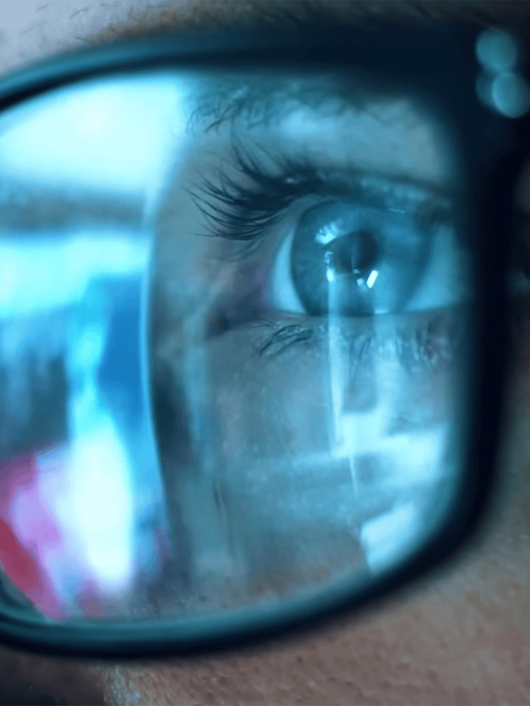 Close-up of a human eye reflecting digital screen content.