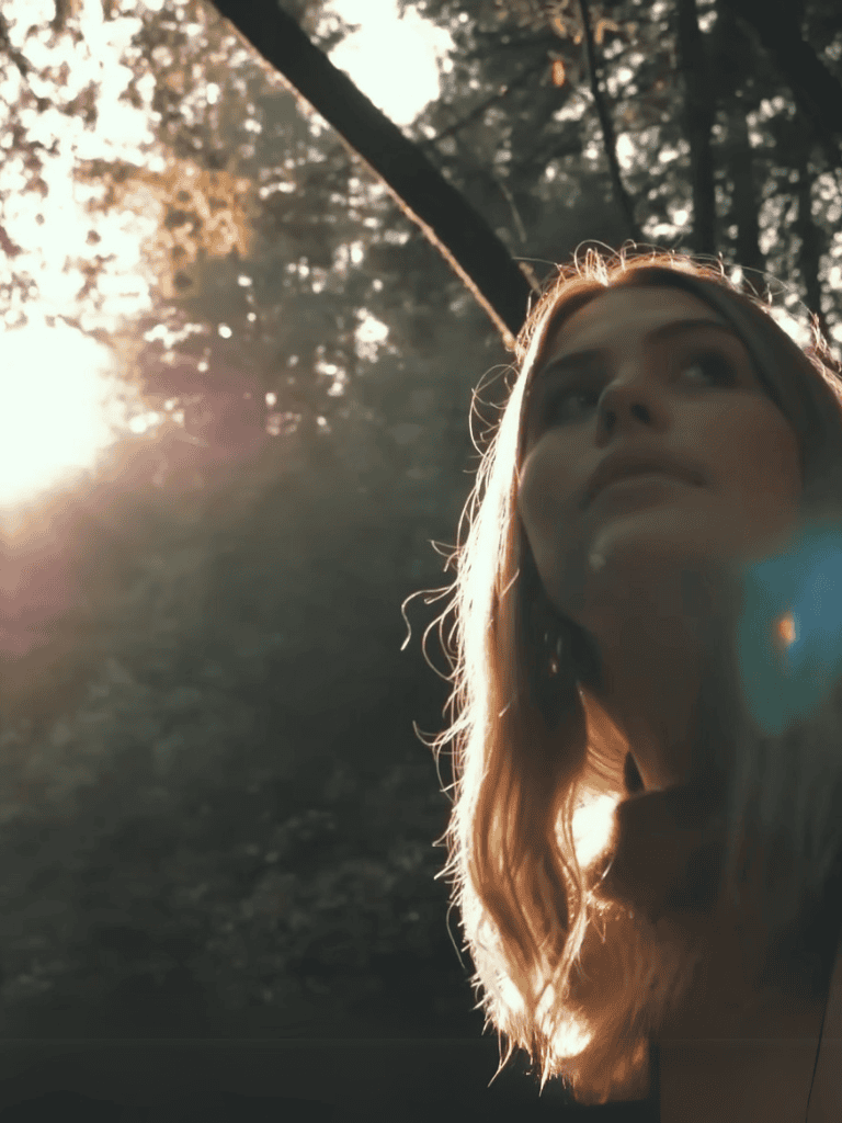 Close-up of a woman and her dog in nature during sunset.