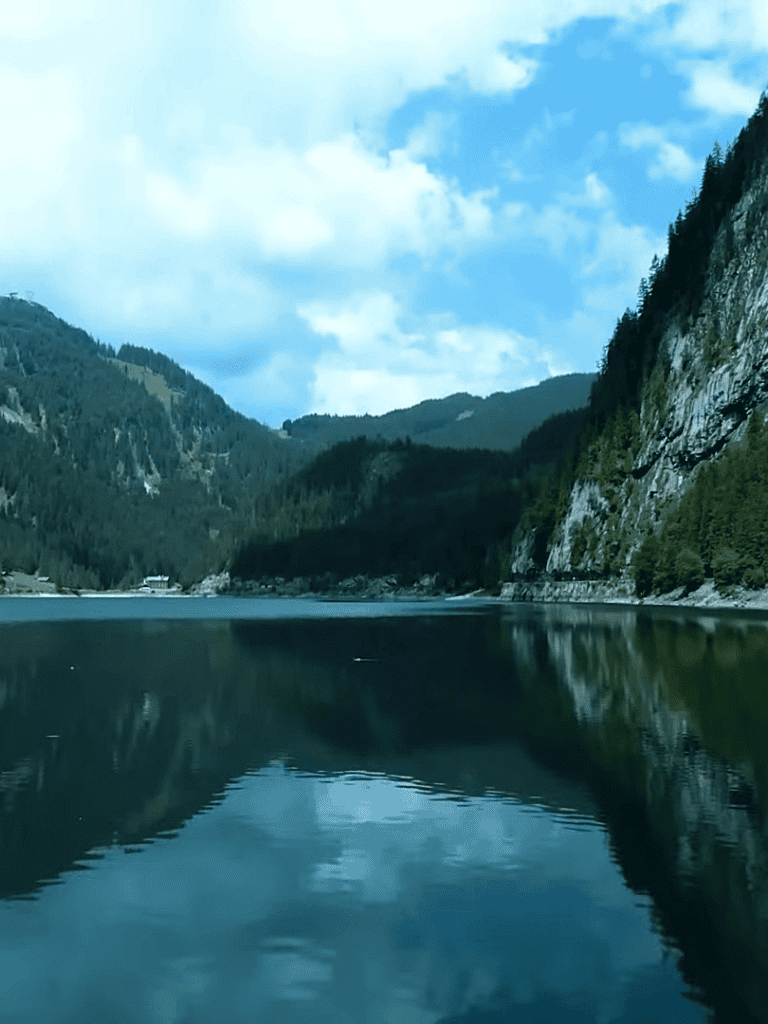 Beautiful mountain lake with calm waters and lush green forests surrounding the area.