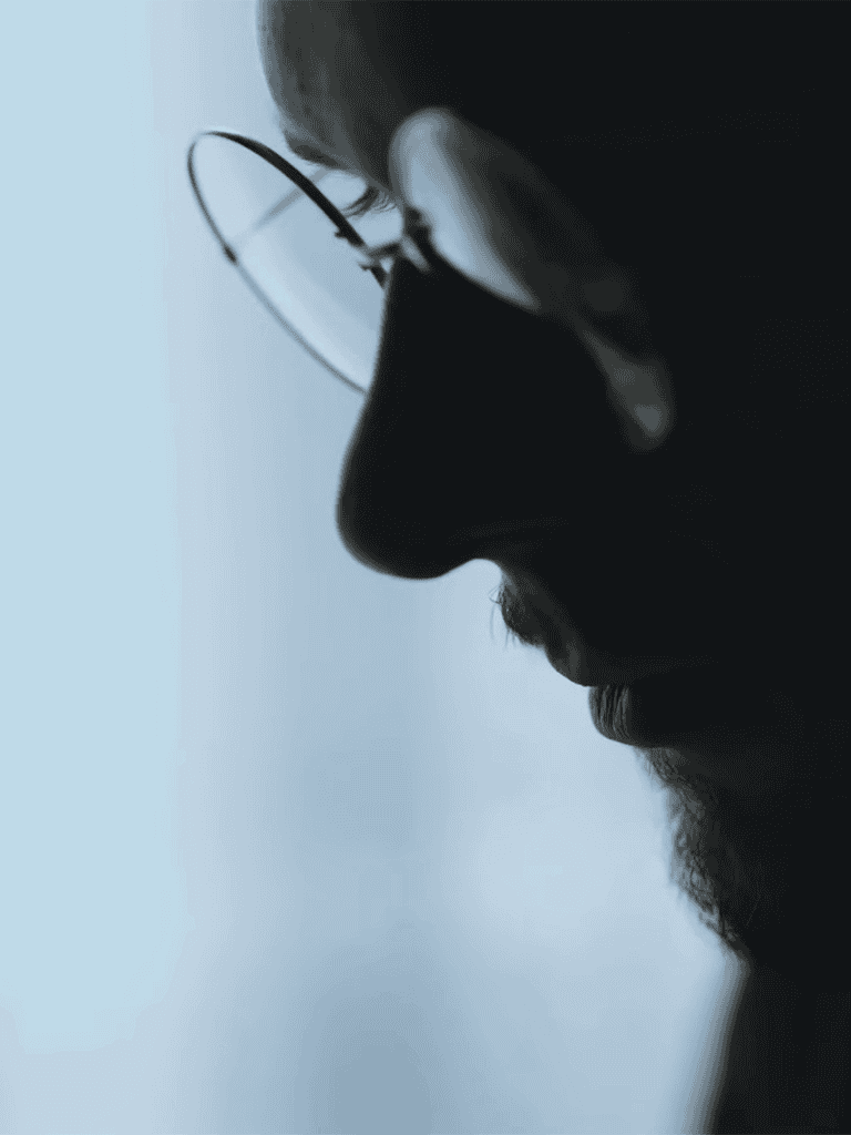 Close-up of a man wearing glasses, emphasizing profile and contemplative expression.