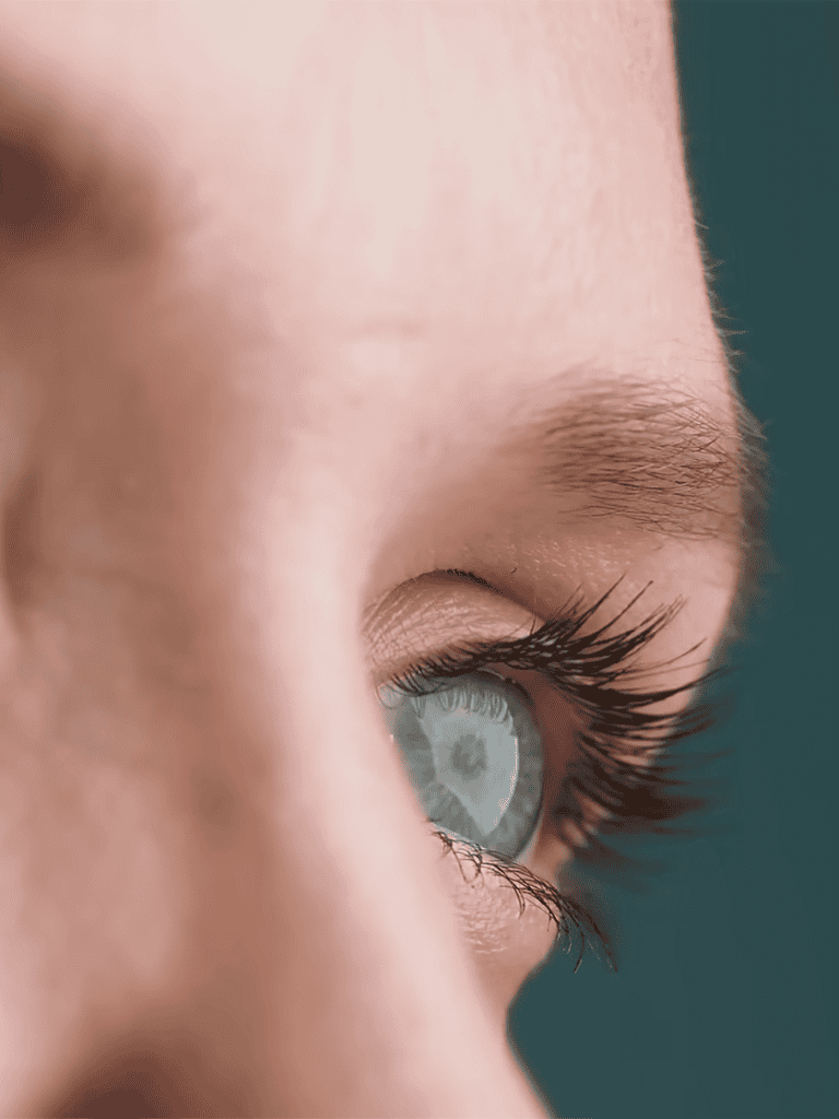 Close-up of a bright blue eye with long eyelashes highlighting eye detail.