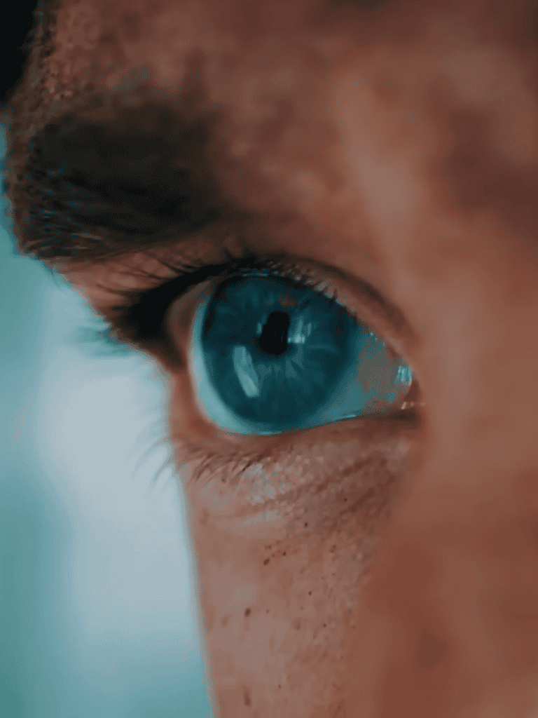 Close-up of a human eye with bright blue iris and detailed textures, emphasizing clarity and focus.