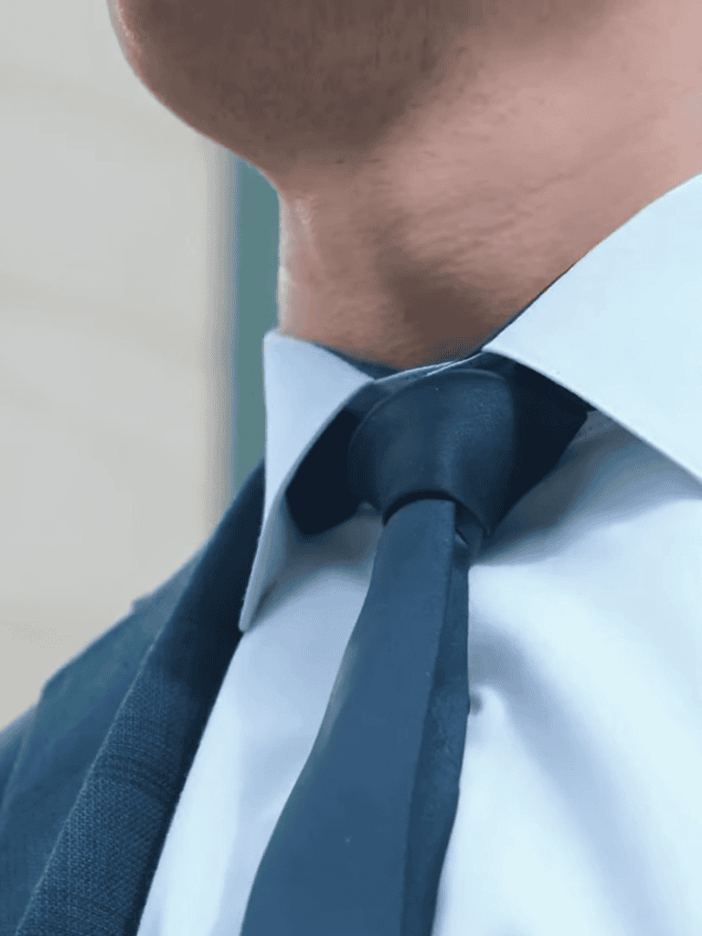Close-up of a person in a suit with a tie, emphasizing professional appearance.