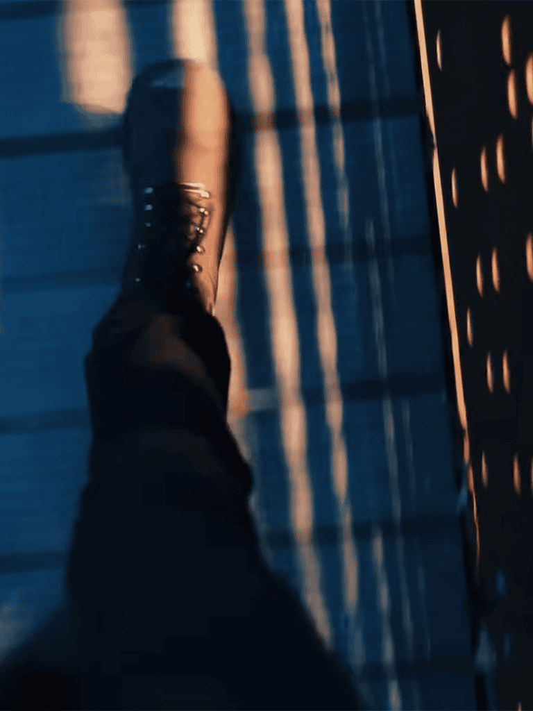 Walking shoe on a checkered floor with warm sunset lighting.